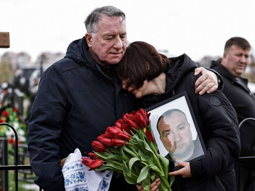 Të afërmit e pikëlluar marrin pjesë në funeralin në varrezat në Bucha-s