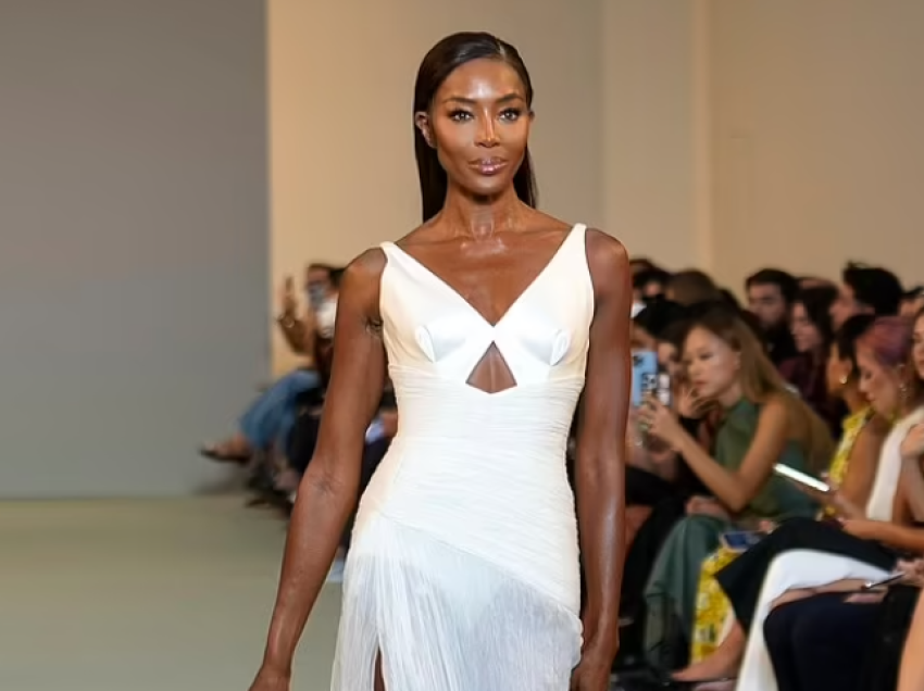 Naomi Campbell modelon një fustan elegant të bardhë